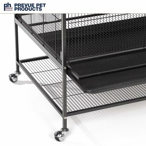 Black pet cage with wheels and tray.